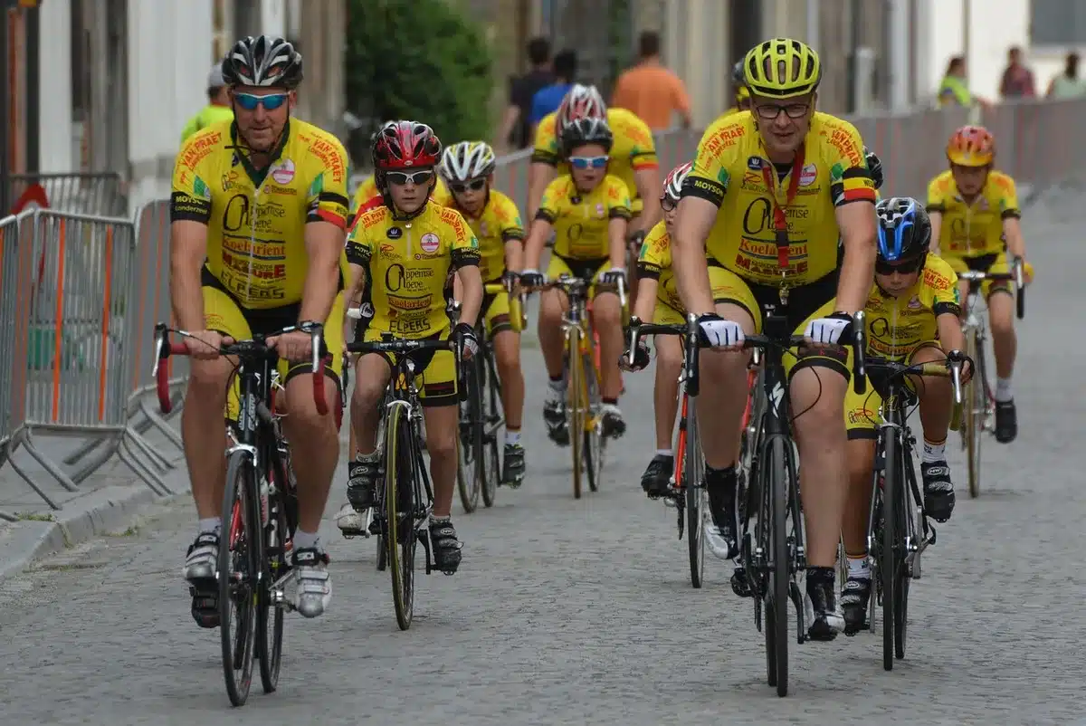 A bright, anonymous cycling jersey on a mannequin stand under a spotlight, hexagonal texture visible but no logos, zip slightly open revealing a hidden tricolor fabric; empty workshop backdrop suggests production and design.
