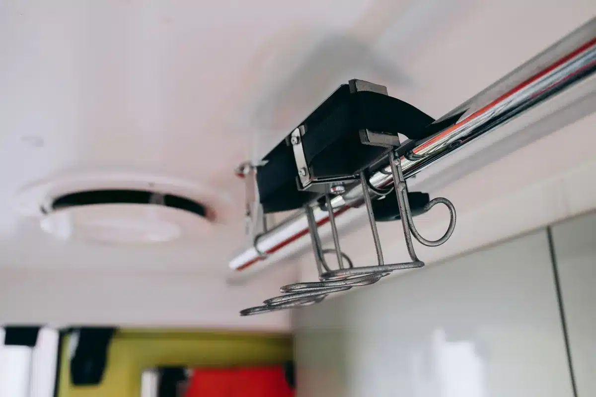 Empty team bus with equipment stacked, spare bicycles leaning against the doorway, anonymous team jackets hanging inside
