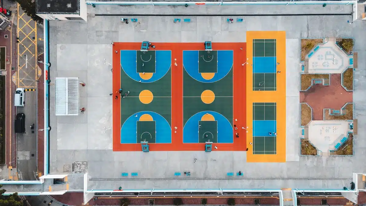 wide shot of an empty basketball arena lit for a night game, a lone ball on the center court