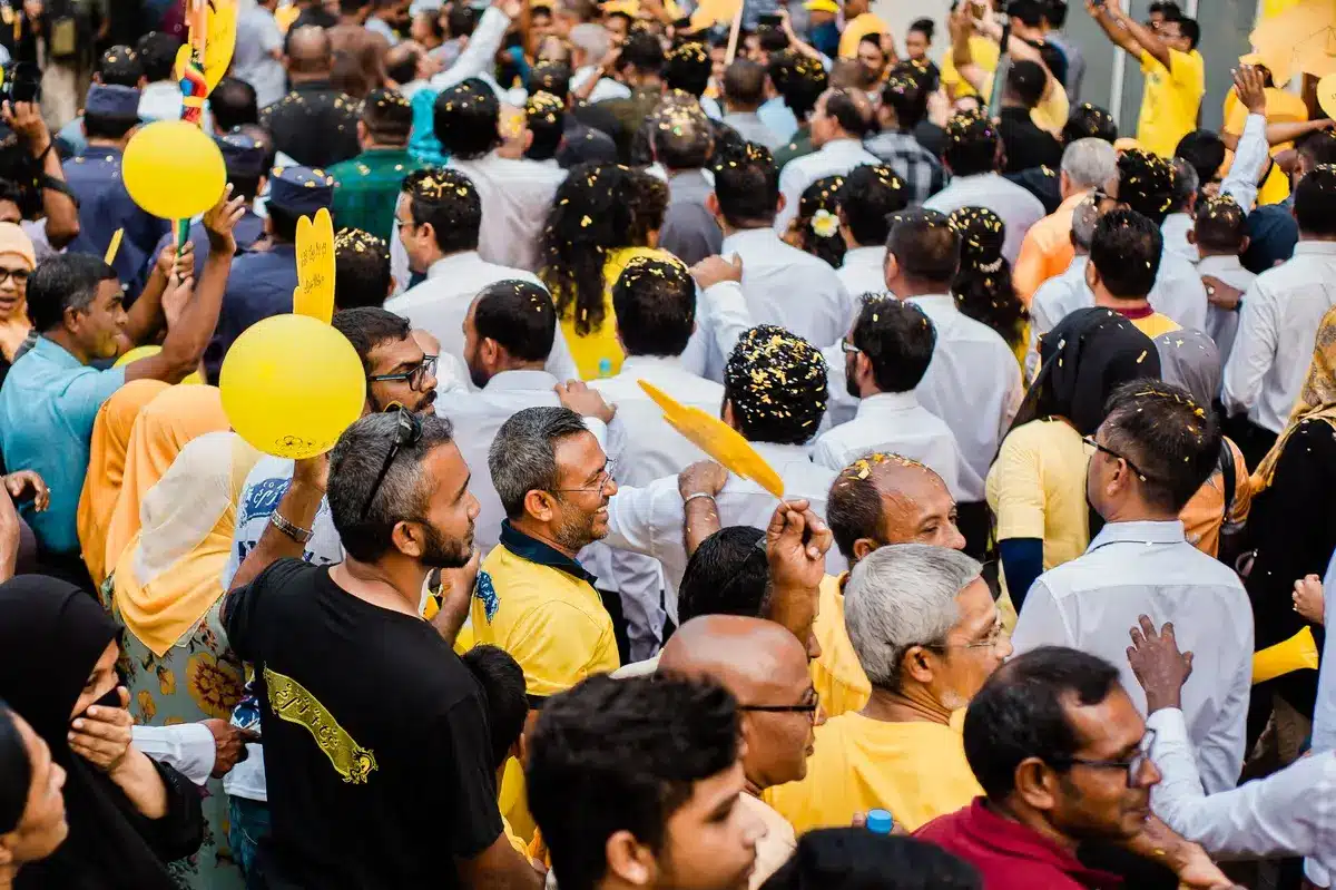 anonymous crowd silhouettes erupting as confetti falls, stadium floodlights glowing